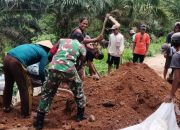 Tumbuhkan Rasa Kebersamaan, Babinsa Gotong Royong Bersama Warga Timbun Jalan Rusak Berlubang